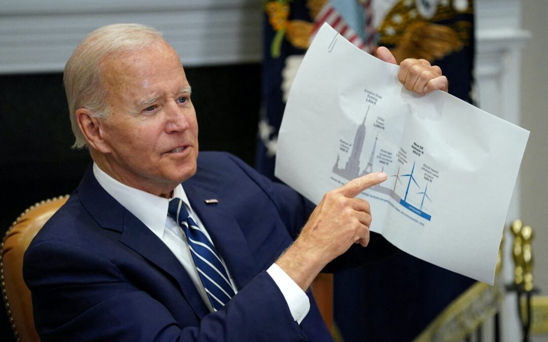 FILE PHOTO: U.S. President Joe Biden holds up a wind turbine size comparison chart while attending a meeting with governors, labor leaders, and private companies launching the Federal-State Offshore Wind Implementation Partnership, at the White House in Washington, U.S., June 23, 2022. REUTERS/Kevin Lamarque/File Photo